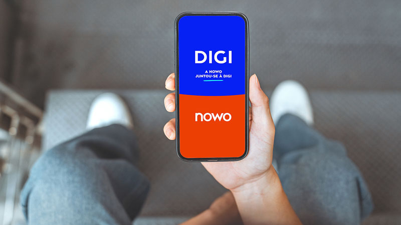 Homem a mostrar telemóvel com campanha da DIGI e NOWO